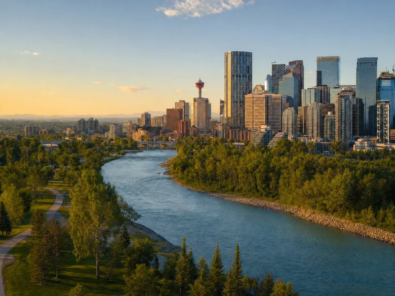 Bow River, Calgary Tower, and the downtown Calgary skyline with distant Rocky Mountain foothills